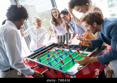 Multiracial people having fun in office room, excited diverse employees enjoying activity at work Stock Photo