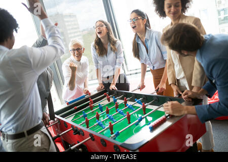 Excited diverse employees enjoying funny activity at work break, creative friendly workers play game Stock Photo