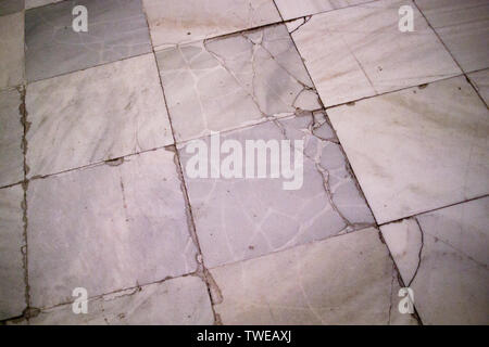 Aged and cracked square marble floor tiles laid in a grid pattern in former hospital building, finished in 1805 in Madrid, Spain Stock Photo