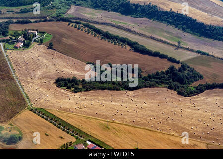 many hay balls on farmed fields aerial view panorama in Italy Stock Photo