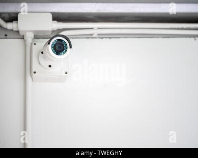 White CCTV camera on white wall background. Modern CCTV security camera with copy space. Stock Photo
