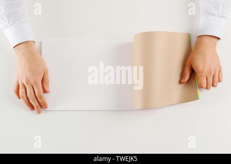 Hand holding blank opened book mock up Stock Photo