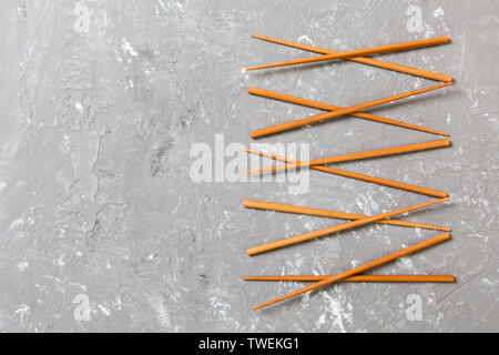 Many bamboo chopsticks on black cement stone background, top view with copy space. a lot of sushi sticks in the form of an ornament. Stock Photo