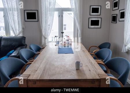 Interior wooden dining table with chairs and blank picture frame on winter season Stock Photo