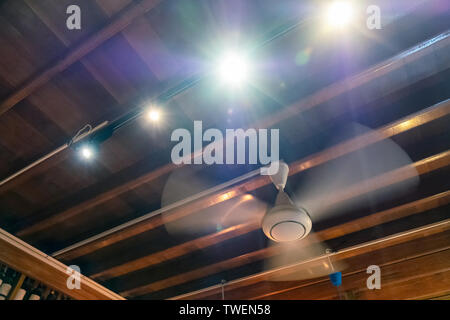 Ancient rotation fan on wood ceiling with light shining decoration at home Stock Photo