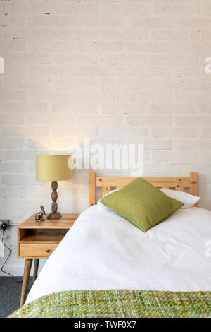 A bedroom in a modern barn conversion home, showing beds and bedside tables in the UK Stock Photo