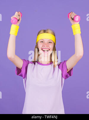 Woman exercising with dumbbells. Easy exercises with dumbbells. Workout with dumbbells. Ultimate upper body workout for women. Girl hold dumbbells wear bright wristbands. Vintage sport concept. Stock Photo