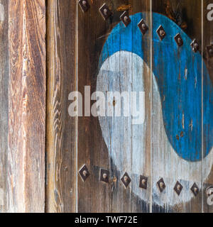 Eum and Yang Symbol, korean variant of Yin and Yang. Colorful retro painting on a old wooden door. Stock Photo