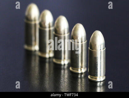 Close up of 9 mm golden pistol bullets ammo on background. Special force units. Stock Photo