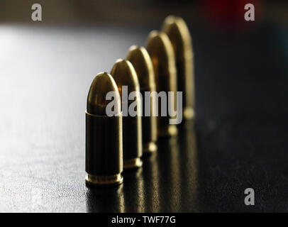 Close up of 9 mm golden pistol bullets ammo on background. Special force units. Stock Photo