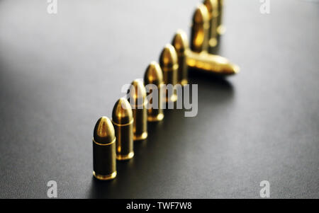 Close up of 9 mm golden pistol bullets ammo on background. Special force units. Stock Photo