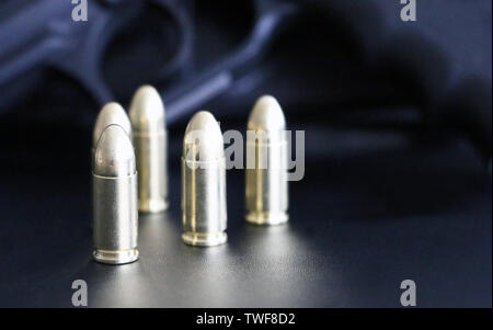 Close up of 9 mm golden pistol bullets ammo on background. Special force units. Stock Photo