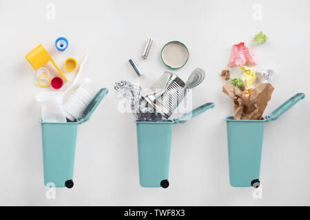 Trash bins and assorted garbage on grey background. Recycle concept Stock Photo