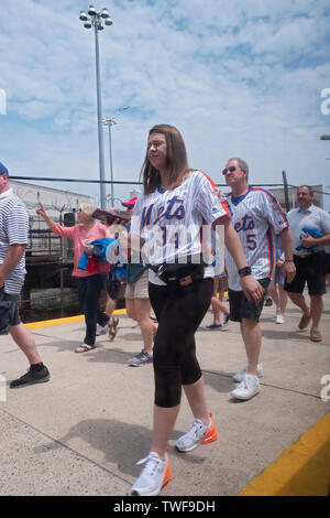 New York Mets baseball fans getting off the Long Island Railroad on their way to Citi Field to see a baseball game. In Flushing, New York. Stock Photo