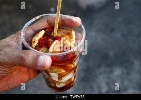 Photo of deep fried fish balls and spicy sweet sauce in a plastic cup Stock Photo