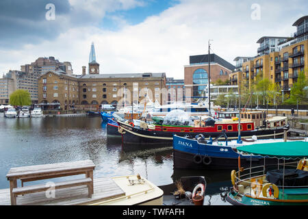 Boats and houseboats moored in St Katherines Dock in Wapping in London. Stock Photo