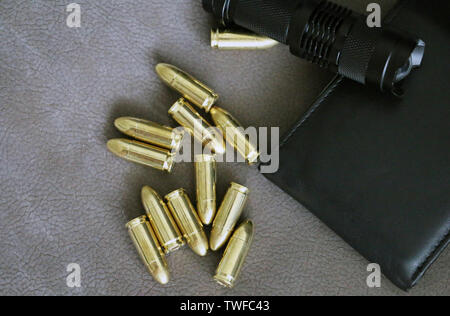 Tactical flashlight, pistol bullets and wallet Stock Photo