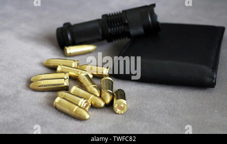 Tactical flashlight, pistol bullets and wallet Stock Photo