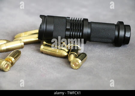 Tactical flashlight and pistol bullets Stock Photo