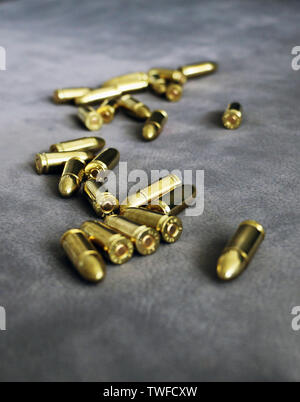 Close up of 9 mm golden pistol bullets ammo on background. Special force units. Stock Photo