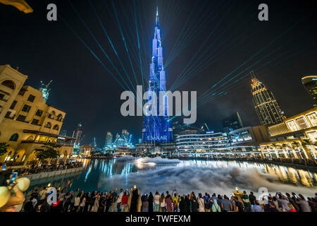 Crowds hold out phones to capture the awe-inspiring light show of the Burj Khalifa in Dubai. Stock Photo