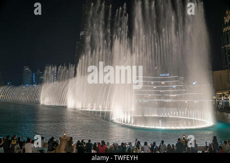 Crowds raise their phones to capture the stunning dancing fountain show in Dubai. Stock Photo