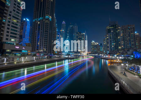 Trails of light from passing dhows enhance the image of Dubai as a city of the future in the Dubai Marina. Stock Photo