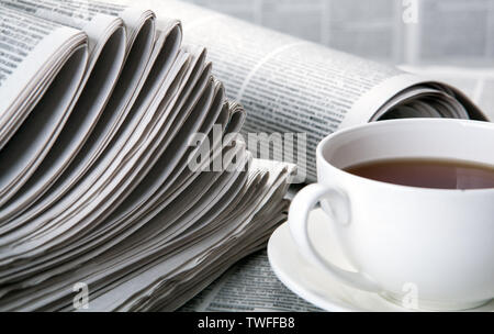 newspapers and a cup of coffee on the table closeup Stock Photo