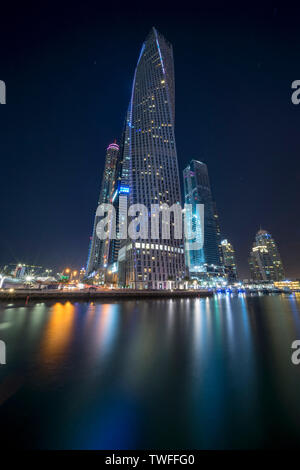 Cayan Tower rising over the shimmering waters of the Dubai Marina. Stock Photo