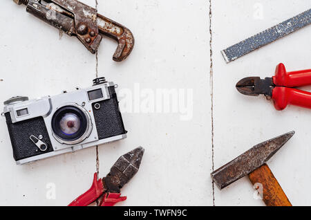 Composition of old tools, pliers, hammer, wrench, nippers and a vintage old film camera. Stock Photo