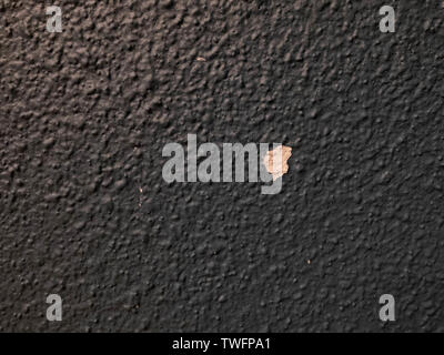 Black plastered textured wall with cracked missing spot Stock Photo