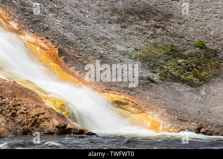 Water running off Excelsior geyser crater into the Firehole river Stock Photo