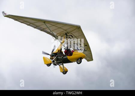 Smart looking yellow QuikR flex wing microlight aircraft flying above ...