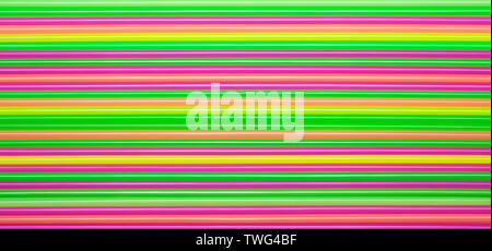 Colored plastic straws or tubes with blue, orange, pink, yellow and green stripes. Abstract background. Stock Photo