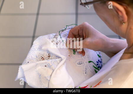 View of a woman engaged in embroidering Stock Photo