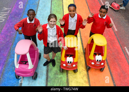 London, UK.  20 June 2019.  Pupils from St George The Martyr CE primary school at a photocall take part in fun activities outside Great Ormond Street Hospital, where the road has been transformed into a rainbow coloured street, during Clean Air Day. [School permission obtained]   Credit: Stephen Chung / Alamy Live News Stock Photo