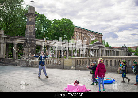 Street entertainer blowing bubbles in Berlin, Germany to a group of children Stock Photo