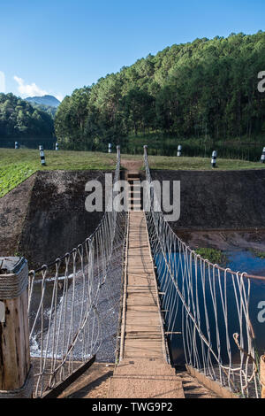 Small suspension bridge is crossing the flood way of the reservoir in the national park. Stock Photo