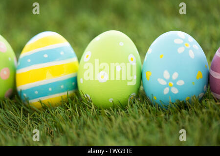 row of colored easter eggs on artificial grass Stock Photo