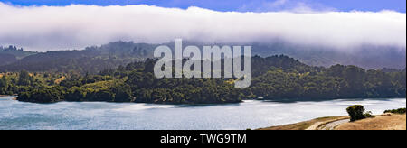 Upper Crystal Springs Reservoir,  part of the San Mateo Creek watershed and Santa Cruz mountains covered with clouds visible in the background; San Ma Stock Photo