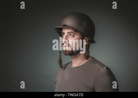 studio portrait of man with military helmet looking away. Concept of army and conflict. Stock Photo