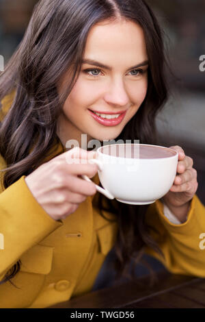 teenage girl drinking hot chocolate at city cafe Stock Photo