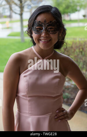 A beautiful teenage girl poses for the camera while attending a masquerade ball at the Fort Wayne Country Club in Fort Wayne, Indiana, USA. Stock Photo
