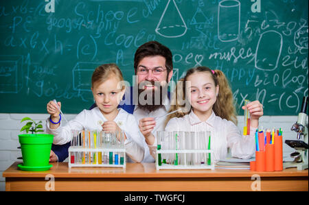 School biology experiment. Explaining biology to children. How to interest children study. Fascinating biology lesson. Man bearded teacher work with microscope and test tubes in biology classroom. Stock Photo