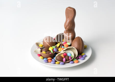 chocolate bunny, eggs and candies on white plate Stock Photo