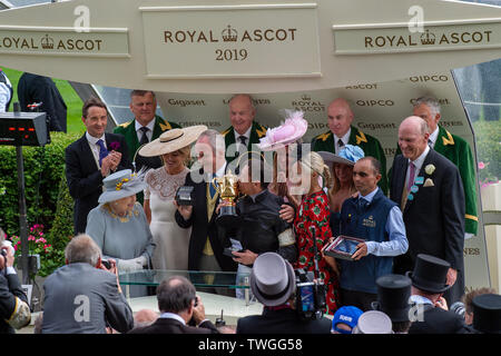 Ascot, Berkshire, UK. 20th June, 2019. Jockey Frankie Dettori has his fourth win of today by winning the Gold Cup (Group 1) at Royal Ascot. He rode horse Stradivarius and Her Majesty the Queen presented the Gold Cup to the owners and trainers on day three of Royal Ascot, Ascot Racecourse.  Credit: Maureen McLean/Alamy Live News Stock Photo