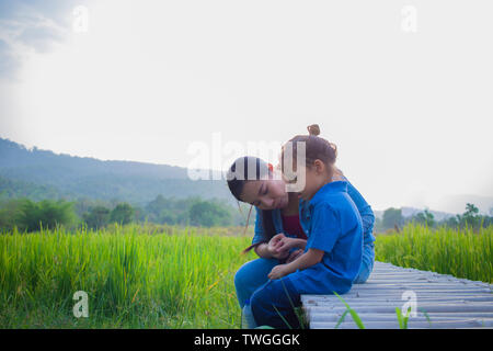 Young mother hugging and soothing a crying little boy, Asian mother trying to comfort and calm down her crying child Stock Photo