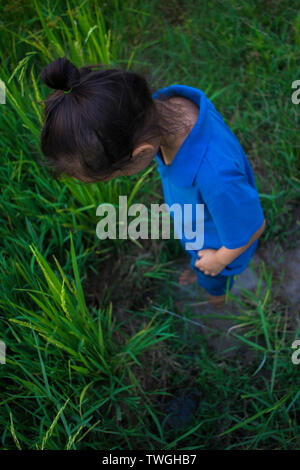 Asian children play jumping in the muddy puddle at rice field. High resolution image gallery. Stock Photo