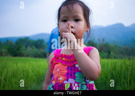 little girl playing in rice field. and have some insect landing on her hand. High resolution image gallery. Stock Photo