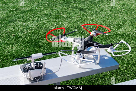 A drone and its controller isolated on a gray bleacher for a picture. Stock Photo